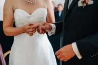 Die Braut steckt ihrem Ehemann den Ring an den Finger